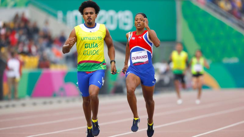 a female vision impaired runner and her guide running on the track