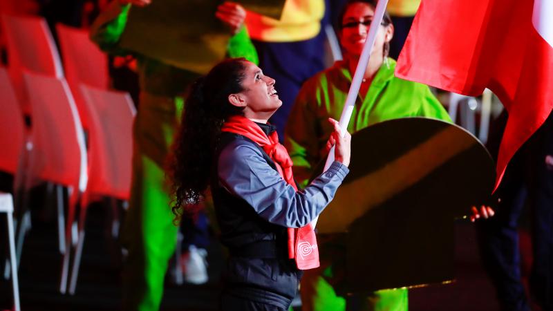 a female athlete carries a flag