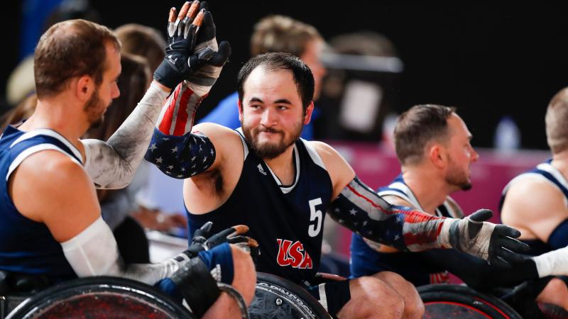 male wheelchair rugby players high-five