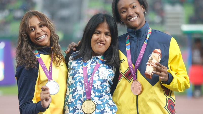 three female Para athletes with their medals on the podium