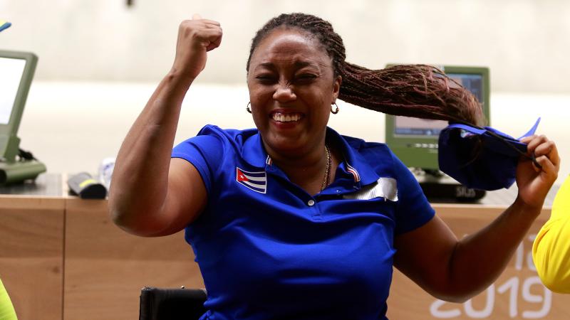 a female Para shooter clenches her fist in celebration