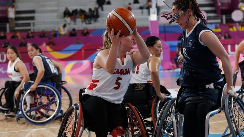 female wheelchair basketball players fight for the ball