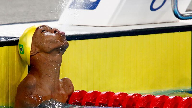 a male Para swimmer sprays water out of his mouth
