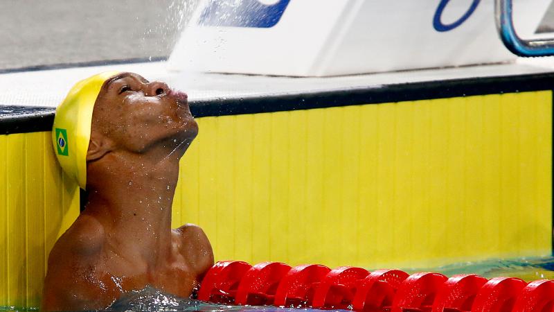 a male Para swimmer sprays water out of his mouth
