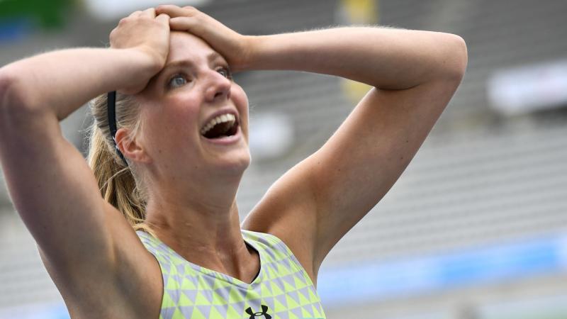 a female Para athlete clutches her head in disbelief