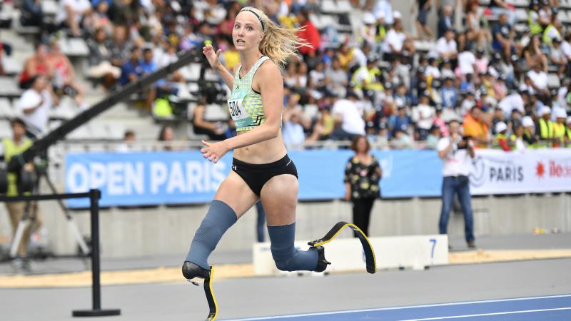 a female double amputee sprinter crosses the finish line