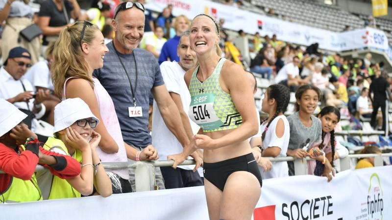 a female Para athlete celebrates with fans