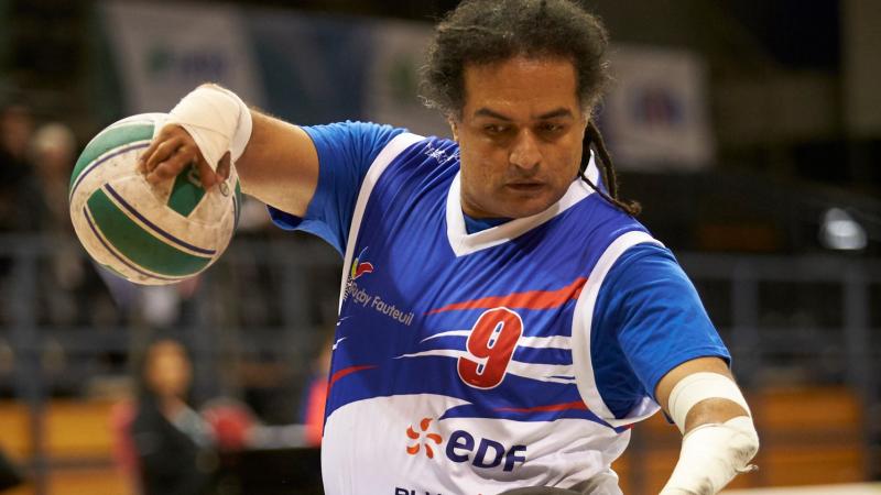 French male wheelchair rugby player holds ball