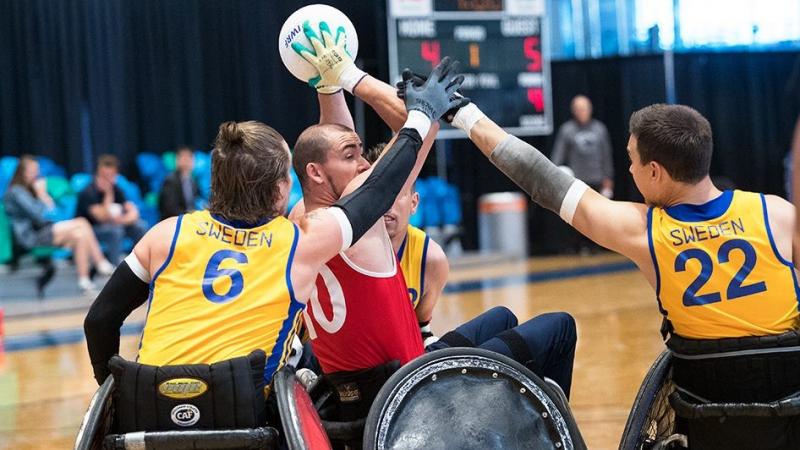 Host of Swedish wheelchair rugby players try to steal ball from Danish player