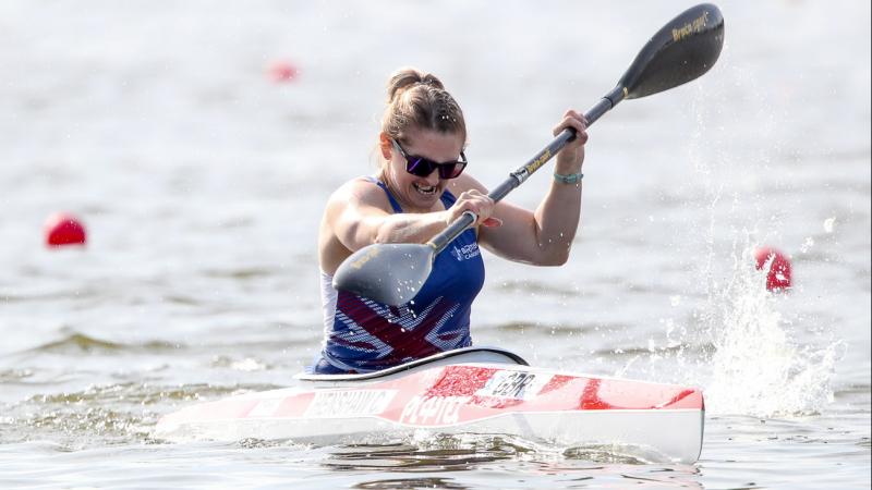 a female Para canoeist mid-stroke on the water