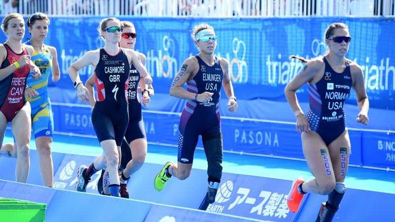 female Para triathletes with prosthetic legs running during a race
