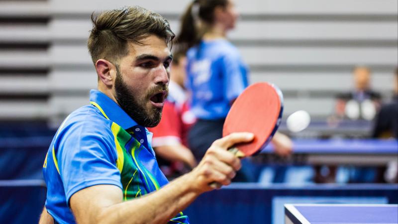 Man in wheelchair returns a shot in table tennis