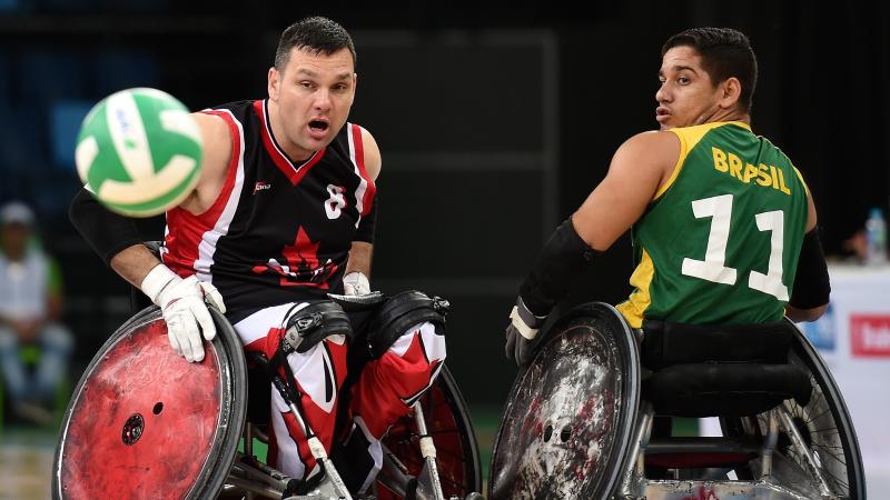 Two male opponents go for wheelchair rugby ball