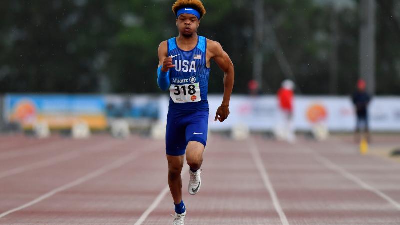 African American teenage male sprints on the track