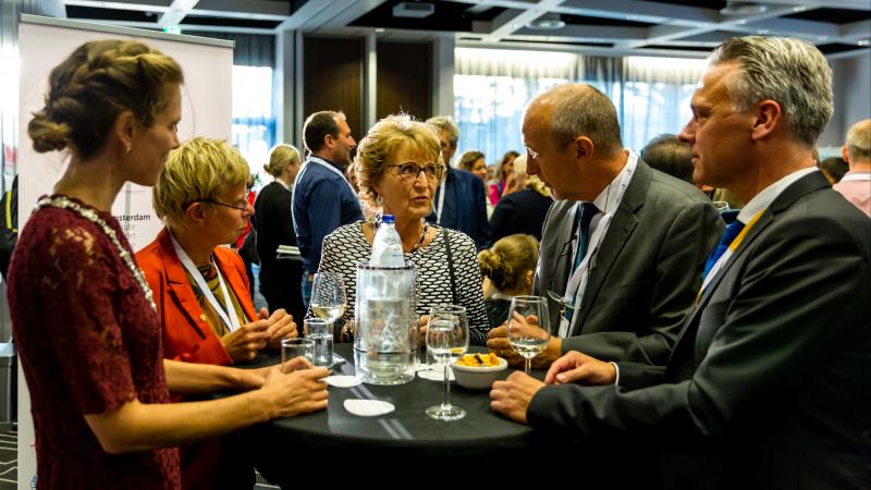 Group of people around a cocktail table during a conference