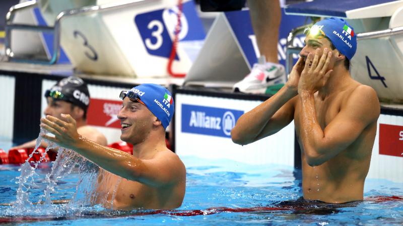 two male Para swimmers celebrate in the water 