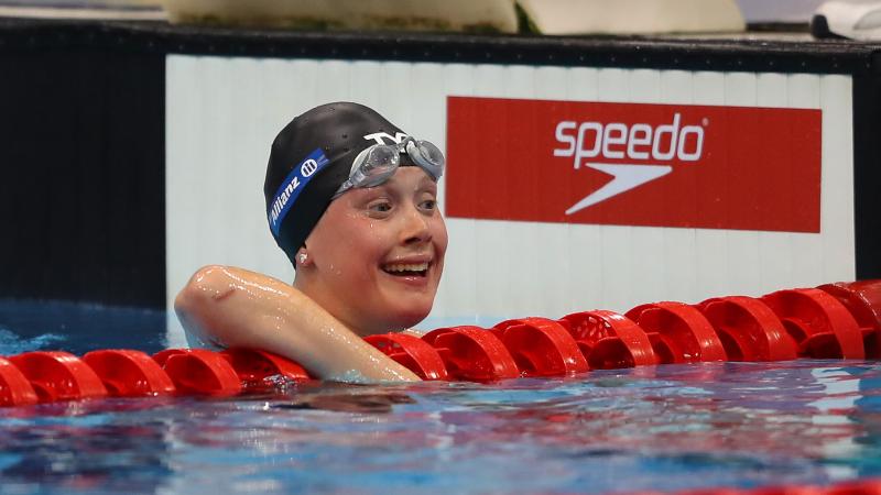 a female Para swimmer celebrates in the pool