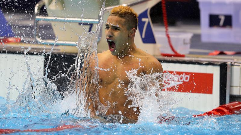 a male Para swimmer celebrates in the water