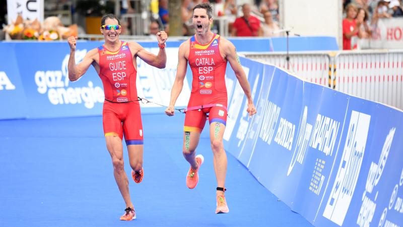 Vision impaired triathlon and his guide celebrate at the finish line