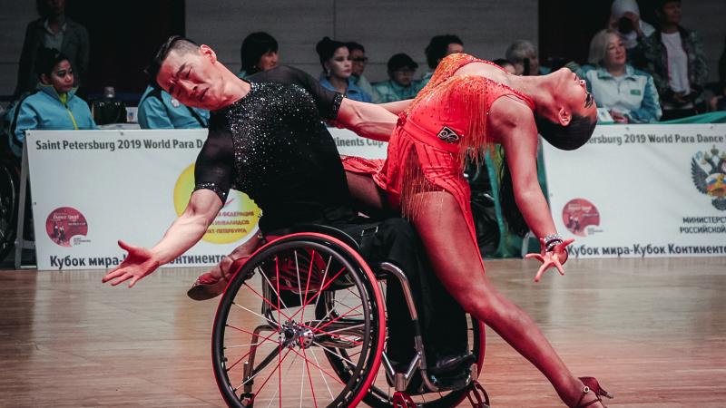 Man in wheelchair holds female standing partner