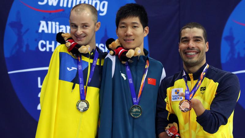 three male Para swimmers on the podium 