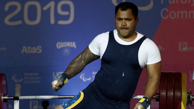 a male powerlifter celebrates on the bench