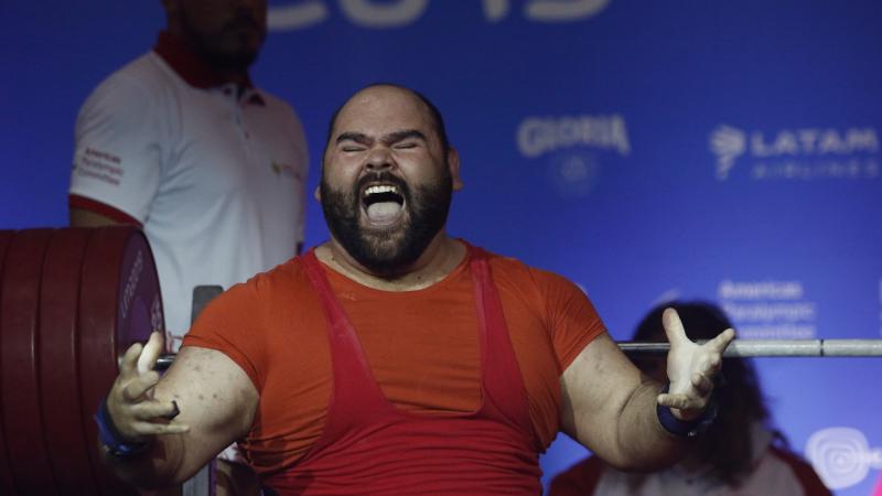 a male powerlifter celebrates on the bench