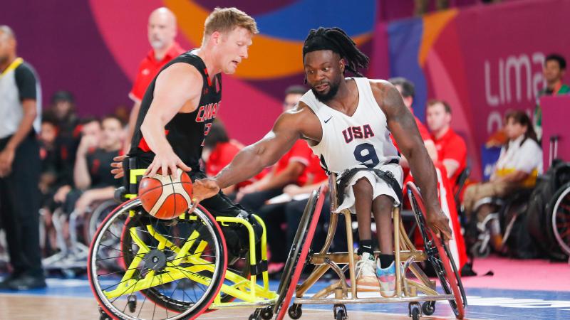 two male wheelchair basketball players fight for the ball