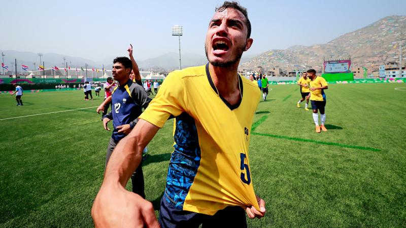 a male football 7 player grabs his Brazil shirt