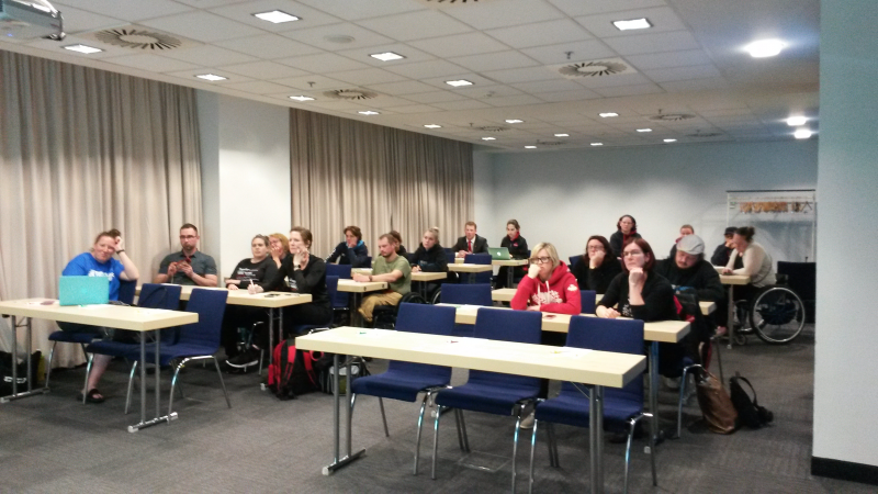 a group of people behind desks in a room
