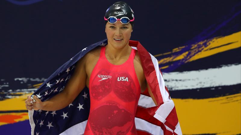 a female Para swimmer wrapped in a USA flag