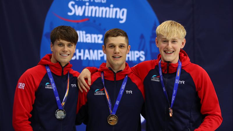 three male Para swimmers on the podium