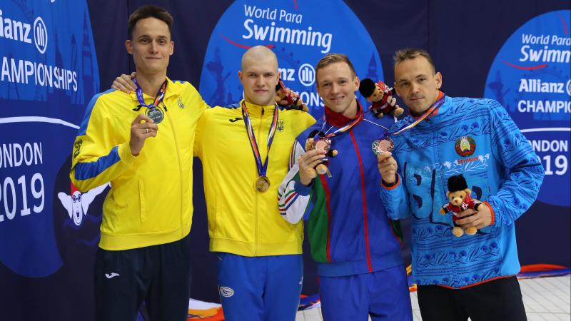four male Para swimmers with their medals