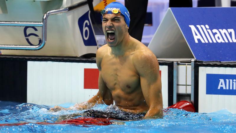 a male Para swimmer celebrates in the water