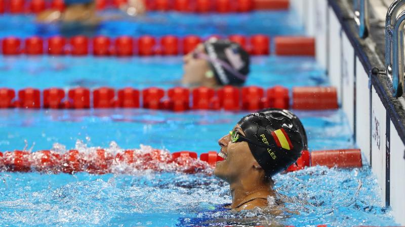 a female Para swimmer celebrates in the pool