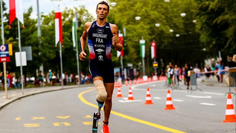 Male triathlete with right leg prosthesis runs  on the road