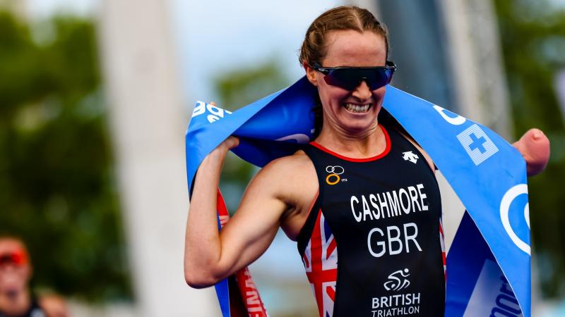 British triathlete with arm disability smile crossing the finish line tape