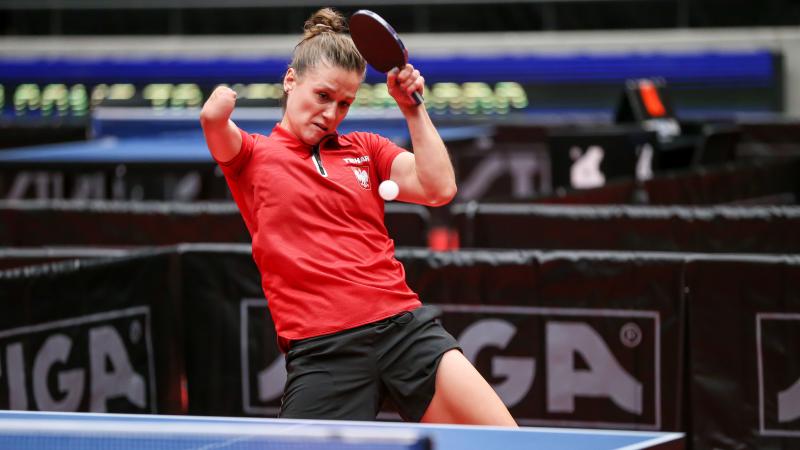 Woman with right arm impairment hits return shot in table tennis
