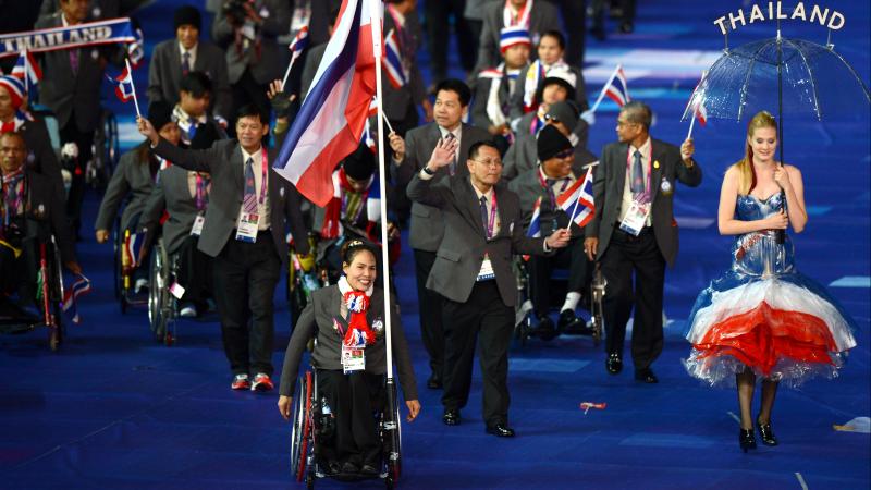 Thai woman in wheelchair leading her delegation as the flag bearer