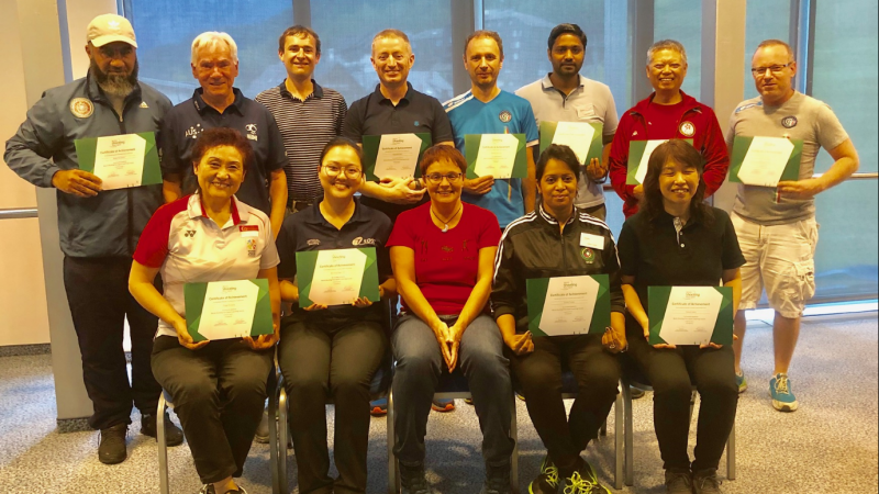 a group of people sitting in a room holding certificates