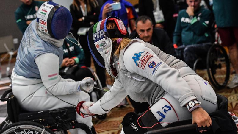 Two women fencing in the foil discipline