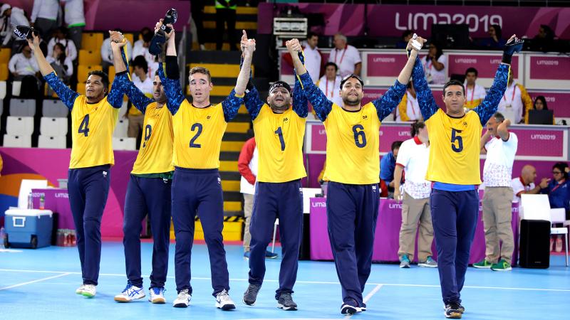 Brazilian goalball players lifting their arms to celebrate after winning the Lima 2019 competition