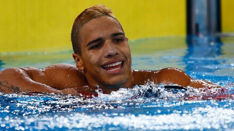 Colombian swimmer Carlos Serrano smiles in the water