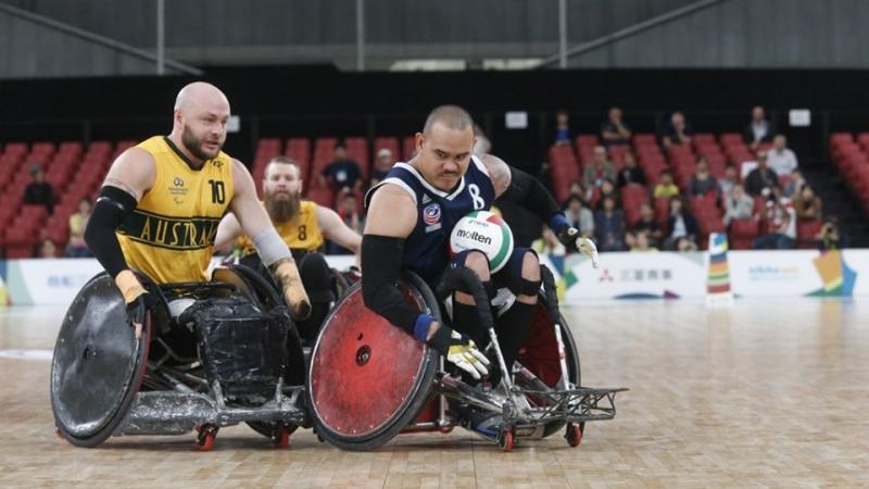 Two wheelchair rugby players battle for the ball