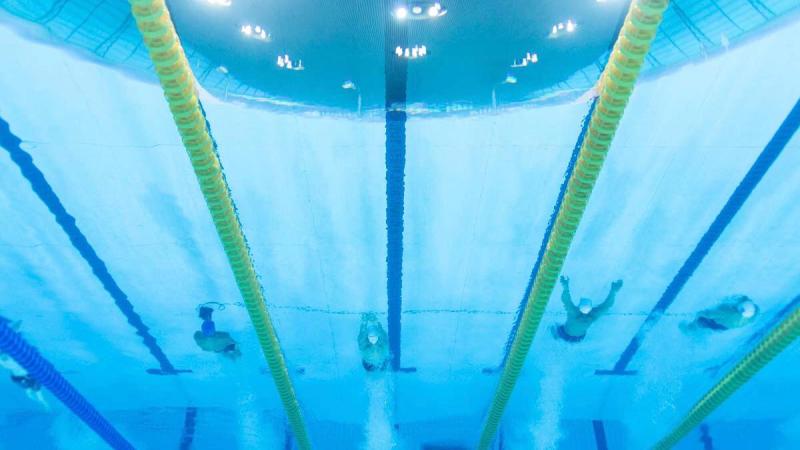 An underwater image of four men swimming in a pool