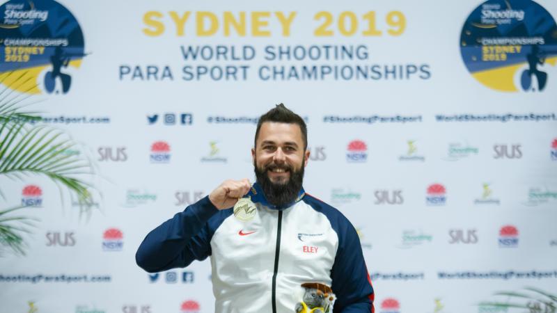 Matt Skelhon poses to the camera while showing his gold medal