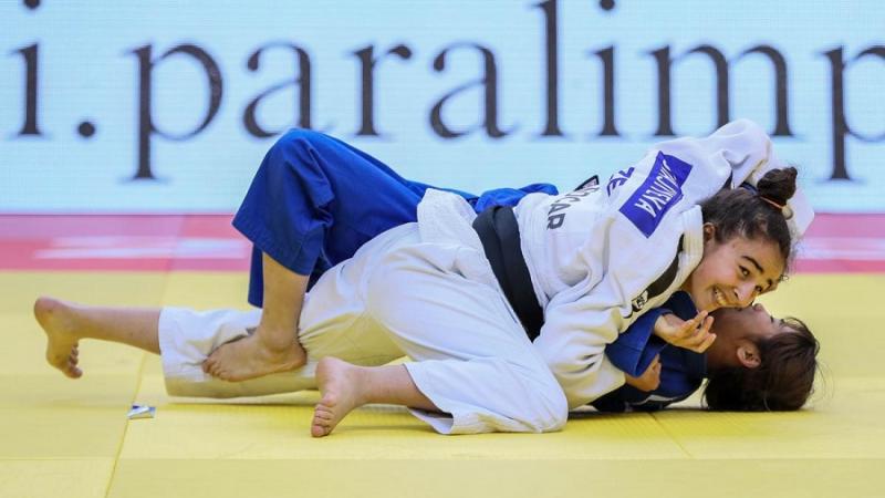Azerbaijani judoka Shahana Hajiyeva holds her rival on the floor and smiles as she beats her