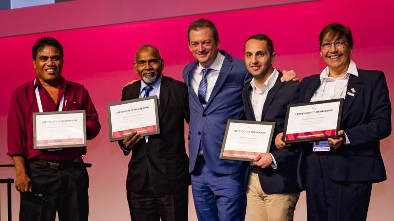 IPC President poses with three NPC presidents holding certificates of membership