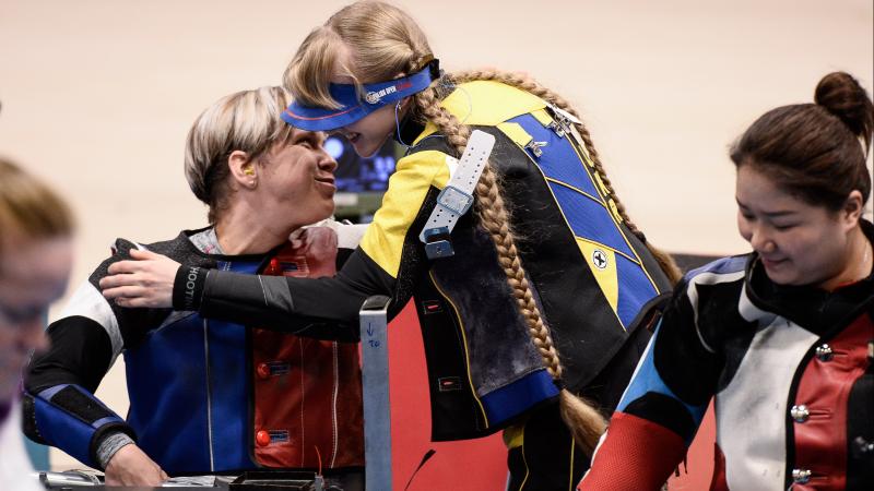 Two female shooters hugging