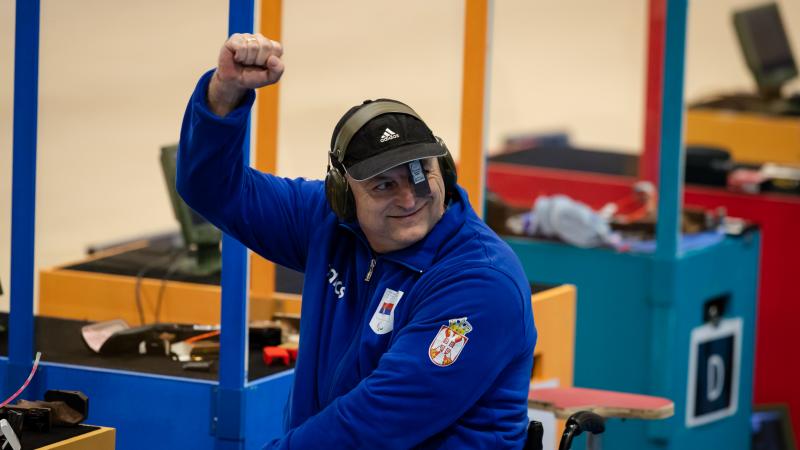 Male rifle shooter waves at crowd